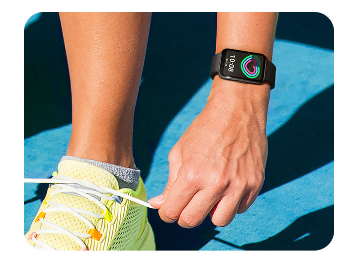 DVemos duas mãos amarrando cadarços de um tênis com uma delas usando o Galaxy Fit3 com o recurso de rastreamento de atividade diária em seu visor.